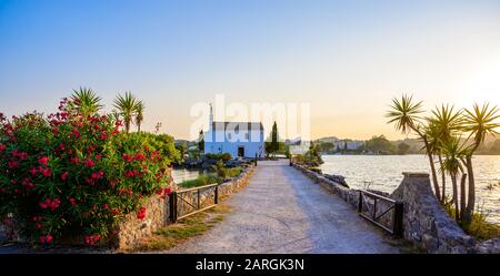 Chiesa di Ypapanti - bellissimo scenario al tramonto nella baia di Gouvia - piccola antica chiesa bianca su un molo, isola di Corfù, Mar Ionio, Grecia, Europa Foto Stock