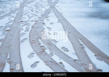 Impronte e pneumatici sulla neve. Foto Stock