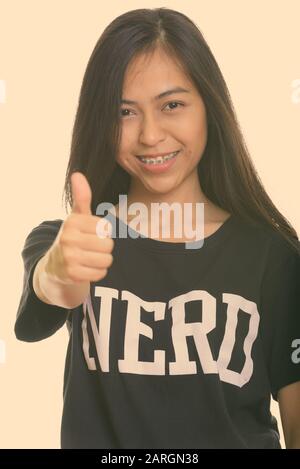 Studio shot di giovani felici Asian teenage nerd ragazza sorridente e dando pollice in alto Foto Stock