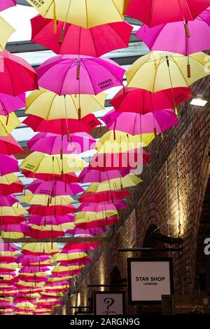 Ombrelloni aperti appesi alla corda nel famoso Camden Market di Londra Foto Stock