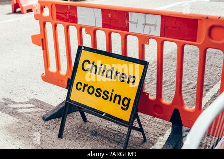 Segnaletica stradale gialla di avvertenza per bambini che attraversano la strada Foto Stock