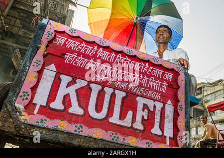 Un fornitore di strada sta vendendo Kulfi, il gelato locale, sulla strada di Khari Baoli nella vecchia Delhi Foto Stock