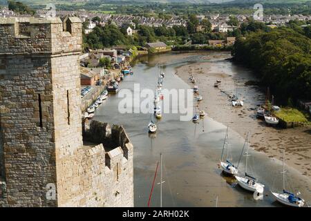 Il fiume Seiont con yacht e barche a ancora visto dalle rovine del castello di Caernarfon Foto Stock