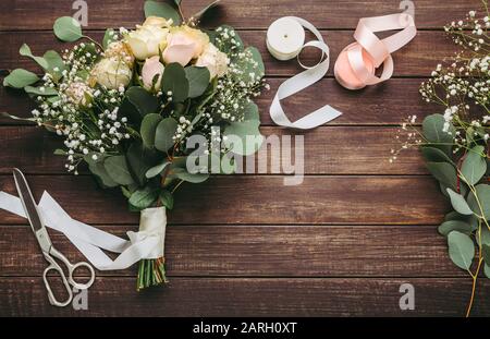 Matrimonio bouquet nuziale di rose con nastro rosa su legno Foto Stock