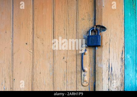 Vecchia porta chiusa con lucchetto e manopola Foto Stock
