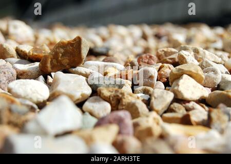 Pietre piccole, ghiaia o ciottoli si chiudono dall'angolo basso con vista prospettica Foto Stock