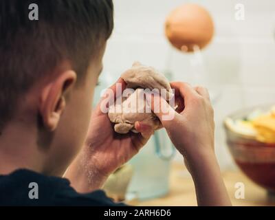 Il bambino fa l'impasto. Primo piano di mani bambino che fanno l'impasto. Foto Stock