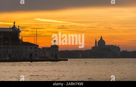Splendido tramonto sulla laguna di Venezia tra le isole di San Giorgio e Giudecca con foschia serale Foto Stock