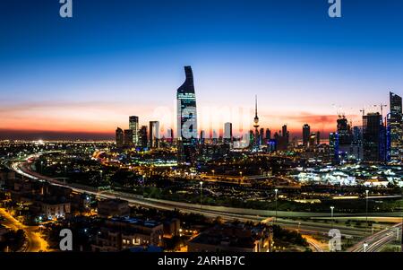 Panorama al tramonto che mostra gli edifici dello skyline di Kuwait City e la circonvallazione Foto Stock