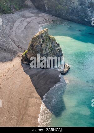 Guardando verso il basso la spiaggia e una piccola isola formata da erosione costiera dal sentiero ciclabile a piedi vicino Portreath, Cornovaglia. Foto Stock