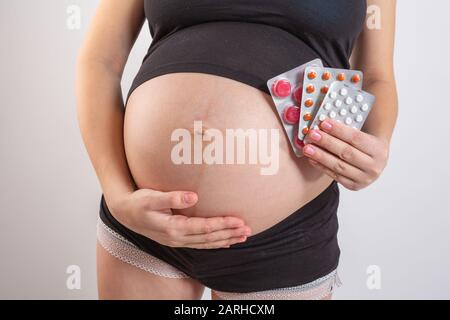 gravidanza, persone e assistenza sanitaria concetto - primo piano di donna incinta. vitamine e minerali per donne in gravidanza. Assunzione di farmaci durante la gravidanza Foto Stock