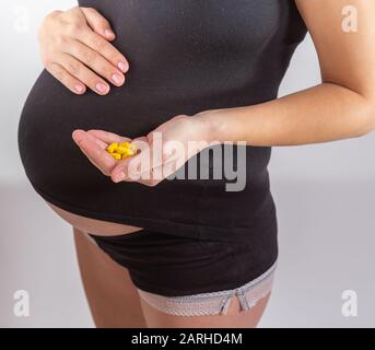 gravidanza, persone e assistenza sanitaria concetto - primo piano di donna incinta. vitamine e minerali per donne in gravidanza. Assunzione di farmaci durante la gravidanza Foto Stock