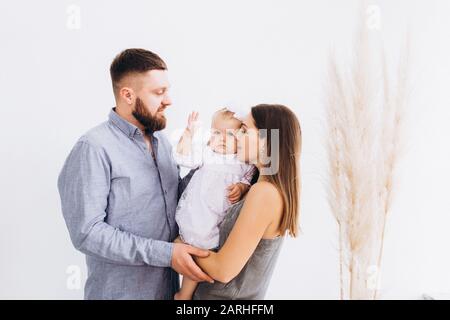 Felice giovane famiglia in uno studio luminoso. Famiglia completa. Foto Stock