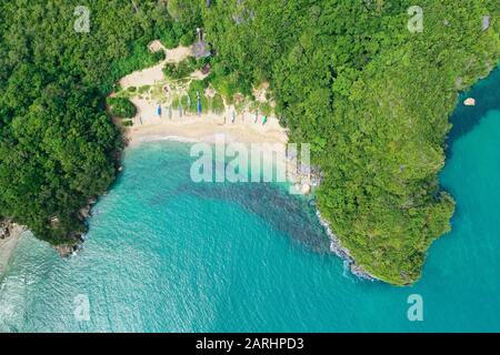 spiaggia di sabbia bianca. Isola rocciosa con una giungla e una laguna turchese, vista aerea. Isole Caramoan, Filippine. Concetto di vacanza estiva e di viaggio. Foto Stock