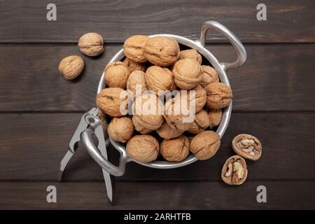 Noci su ciotola su tavolo di legno scuro. Juglans regia Foto Stock