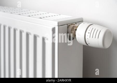 Primo piano della valvola del radiatore termostatico / TVR montata sul radiatore del sistema di riscaldamento dell'acqua calda domestico per controllare la temperatura di un ambiente Foto Stock