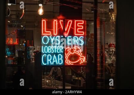 Cartello al neon 'live oysters aragosta granchio' in un ristorante Foto Stock