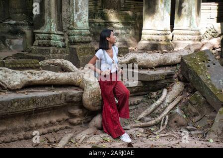 Bella, bella, giovane ragazza tailandese sta esplorando le antiche rovine di Angkor Wat (Città / capitale dei Templi) complesso tempio indù a Siem Reap, Cambogia Foto Stock