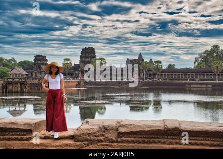 Bella, bella, giovane ragazza tailandese sta esplorando le antiche rovine di Angkor Wat (Città / capitale dei Templi) complesso tempio indù a Siem Reap, Cambogia Foto Stock