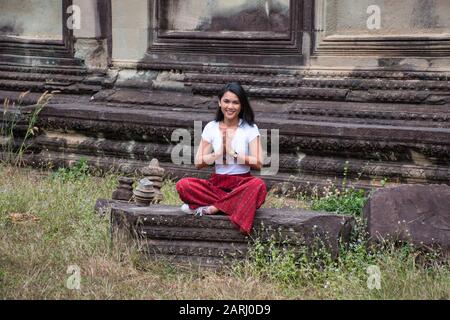 Bella, bella, giovane ragazza tailandese sta esplorando le antiche rovine di Angkor Wat (Città / capitale dei Templi) complesso tempio indù a Siem Reap, Cambogia Foto Stock