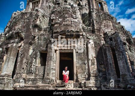 Bella, bella, giovane ragazza tailandese sta esplorando le antiche rovine di Angkor Wat (Città / capitale dei Templi) complesso tempio indù a Siem Reap, Cambogia Foto Stock