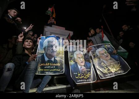 28 gennaio 2020, territori palestinesi, Gaza City: I dimostranti palestinesi hanno immagini del presidente palestinese Mahmoud Abbas durante una dimostrazione contro il piano di pace in Medio Oriente del presidente degli Stati Uniti Donald Trump. Foto: Mohammed Talatene/Dpa Foto Stock