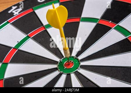 Frecce rosse e gialle che colpiscono nel centro di destinazione di dartboard. Successo che colpisce obiettivo obiettivo obiettivo obiettivo raggiungimento concetto Foto Stock