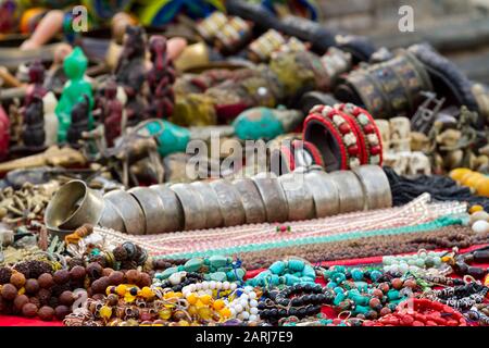 Messa a fuoco selettiva. Alcuni souvenir sul mercato di strada stallo vicino Bodnath stupa, Kathmandu, Nepal. Foto Stock