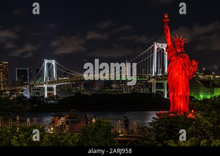 Vista notturna della replica della Statua della libertà e del Rainbow Bridge che collega il centro di Tokyo all'isola artificiale di Odaiba, Giappone Foto Stock