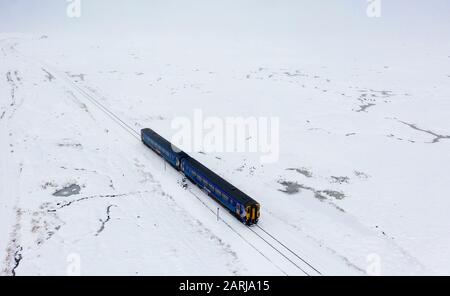 Corrour, Scozia, Regno Unito. 28 Gennaio 2020. Un treno Scotrail viaggia attraverso la neve pesante a Corrour sulla strada itÕs da Mallaig a Glasgow sulla West Highland Line. La stazione Corrour è la più alta della Gran Bretagna ad un'altezza di 1338 piedi sopra il livello del mare. Iain Masterton/Alamy Live News. Foto Stock