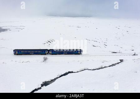 Corrour, Scozia, Regno Unito. 28 Gennaio 2020. Un treno Scotrail viaggia attraverso la neve pesante a Corrour sulla strada itÕs da Mallaig a Glasgow sulla West Highland Line. La stazione Corrour è la più alta della Gran Bretagna ad un'altezza di 1338 piedi sopra il livello del mare. Iain Masterton/Alamy Live News. Foto Stock