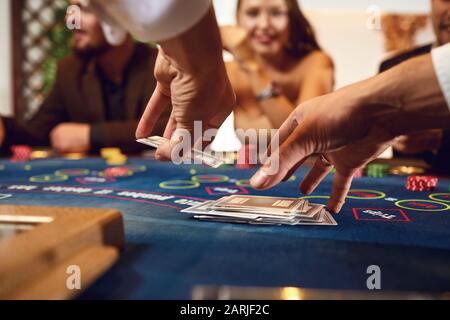 Croupier contiene carte da poker nelle sue mani a una tabella in un casinò. Foto Stock