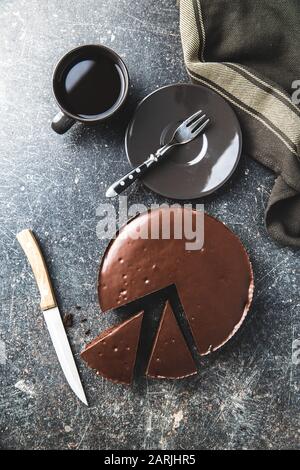 Torta brownies al cioccolato e tazza di caffè su vecchio tavolo da cucina. Foto Stock