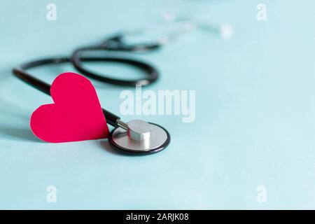 Stetoscopio del medico con cuore rosso. Concetto medico sanitario. Spazio di copia. Foto Stock