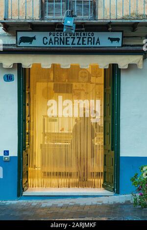 Italia, Sicilia, Provincia Di Palermo, Castelbuono. 11 Aprile 2018. La porta per una piccola carnezzeria, o macellaio negozio. Foto Stock