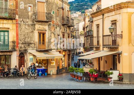 Italia, Sicilia, Provincia Di Palermo, Castelbuono. 11 Aprile 2019. In bicicletta passando davanti ai caffè nella piazza di Castelbuono. Foto Stock