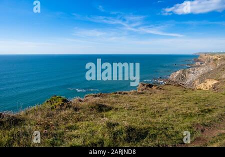 La costa rocciosa dell'Atlantico della Cornovaglia settentrionale vista dal South West Coast Path sopra Bude Bay Foto Stock