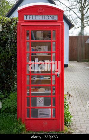 Red British Telephone Box utilizzato come sede di prestito di libri nel piccolo villaggio di Abington Pigotts, Cambridgeshire, Regno Unito. Foto Stock