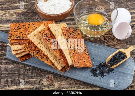 Cracker Di Crunchy Di Seme Nero. Cracker di semi neri su sfondo di legno. Foto Stock