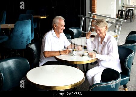 Coppia sposata matura: Una data del caffè in un caffè locale lungo la costa. Carino coppia caucasica passare insieme il tempo in vacanza, felice insieme. Foto Stock