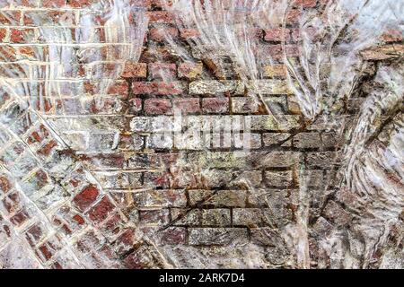 Vista dettagliata di primo piano su muri di mattoni danneggiati con crepe Foto Stock