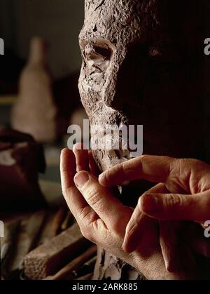 Scultori mani sul lavoro amorevolmente creare un bel viso da un grumo di argilla Foto Stock