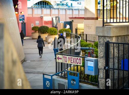 Un cartello che indica il Messico, con vista posteriore delle persone che camminano verso il confine USA-Messico in un punto di check-in a Nogales, AZ, USA Foto Stock