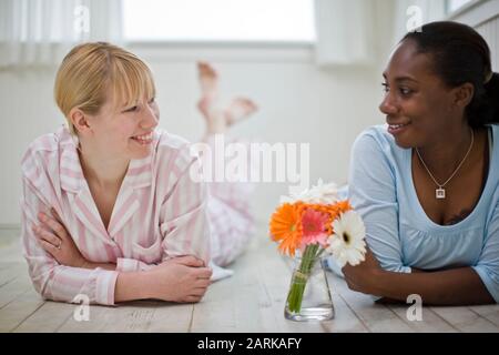 Le donne che giace sul piano di casa in pigiama Foto Stock