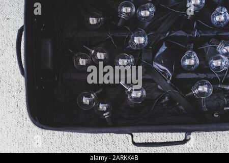 fuga del cervello concettuale ancora vita, valigia aperta con stringa di lampadine simbolo di persone altamente addestrate spostare paese per migliorare la loro vita conditi Foto Stock