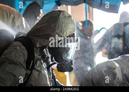 U.s. Marine Corps Lance Cpl. Kimberly Ortiz Marrero, nativo di Lancaster, N.Y. e rappresentante per la sicurezza e il materiale pericoloso del battaglione 3rd Transportation Support, è in piedi durante la decontaminazione durante il corso operazioni sui rifiuti pericolosi e risposta alle emergenze a Camp Foster, Okinawa, Giappone, 19 settembre 2019. Dopo aver completato un esercizio, tutti gli studenti che indossavano abiti per materiali pericolosi dovevano sottoporsi a una procedura di decontaminizzazione dove entravano in una tenda e venivano irrorati con acqua. (STATI UNITI Foto del corpo marino di Lance Cpl. Ryan H. Pulliam) Foto Stock