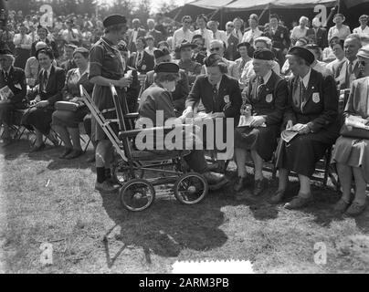 Regina Juliana e Principessa Marijke al Goudsberg a 40 anni Dutch Boy Scout's Guild (N.P.G.) Celebration 40th anniversario N.P.G. sul Goudsberg a Lunteren. Patron Queen Juliana dà qualcosa a un Boy Scout in una sedia a rotelle Annotazione: Proprio accanto alla Regina Juliana il presidente della NPG, Sig.ra J. van Nispen-van Wely Data: 22 maggio 1956 posizione: Pranzo Parole Chiave: Anniversari, regine, Boy Scout, principesse Nome personale: Juliana (queen Netherlands) Nome istituzione: Associazione Olandese Boy Scout Foto Stock