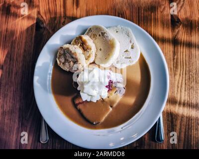 Svickova na smetane (manzo in salsa di panna acida) con panna montata e mirtilli rossi serviti con impastatore (gnocchi di pane), cibo tradizionale ceco Foto Stock