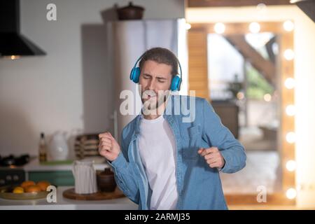 Uomo che indossa gli auricolari blu godendo della sua canzone preferita Foto Stock