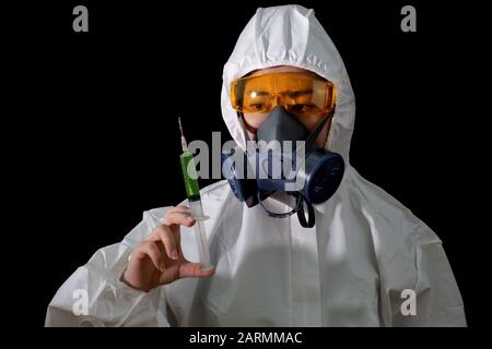 Donna in un abbigliamento protettivo chimico e maschera antigas con occhiali su sfondo bianco, scienziato femminile in tuta di sicurezza Foto Stock